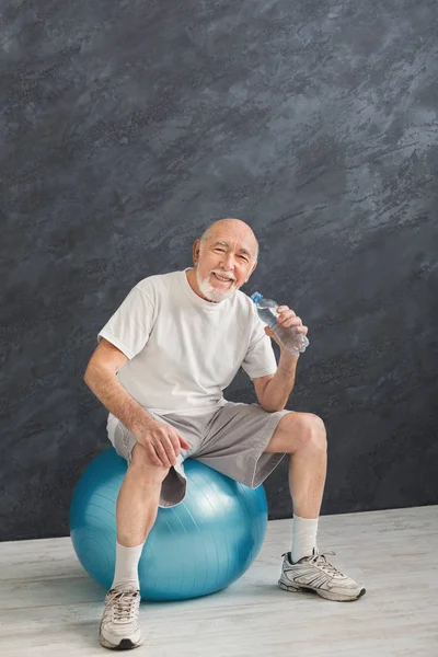 Spragniony starszy człowiek o odpoczynku po treningu — Zdjęcie stockowe