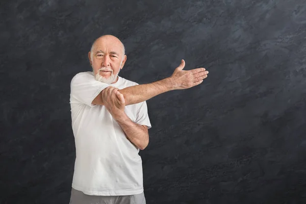 Senior man uitrekken handen binnenshuis — Stockfoto