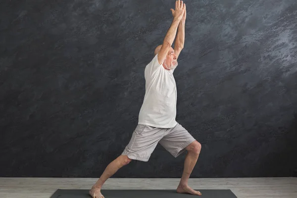Homme âgé pratiquant le yoga à l'intérieur — Photo