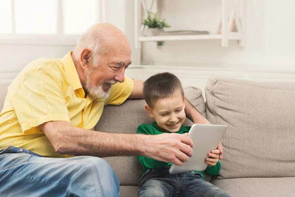 Старший чоловік дивиться відео на планшет з онуком — стокове фото