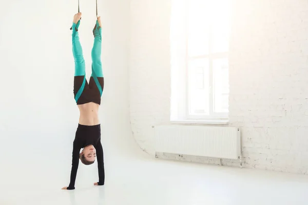 Mujer practicando fly yoga sobre fondo blanco — Foto de Stock