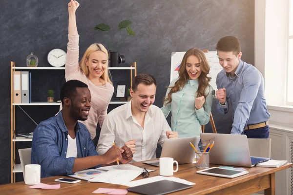 Joven equipo de negocios disfrutando del éxito en la oficina — Foto de Stock