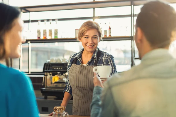 Barista sorridente experiente fazendo café para os clientes — Fotografia de Stock