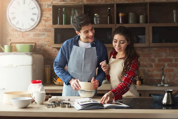 Feliz joven mujer y hombre horneando en la cocina loft —  Fotos de Stock