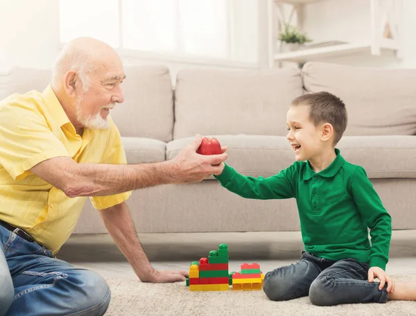 Мальчик играет с дедушкой в строительный комплект — стоковое фото