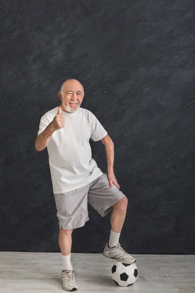 Senior mit Fußballball zeigt Daumen hoch — Stockfoto