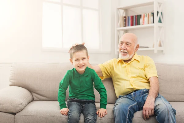 Мальчик сидит на диване со своим дедушкой — стоковое фото
