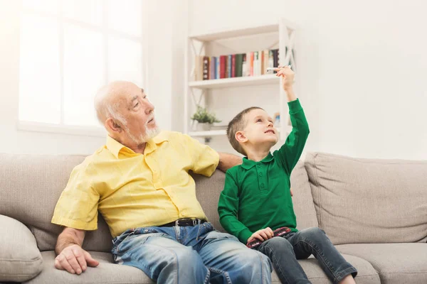 Pojke som leker med leksak rutan med sin farfar — Stockfoto