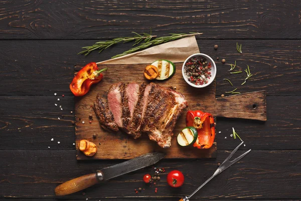 Grilled meat and vegetables on rustic wooden table