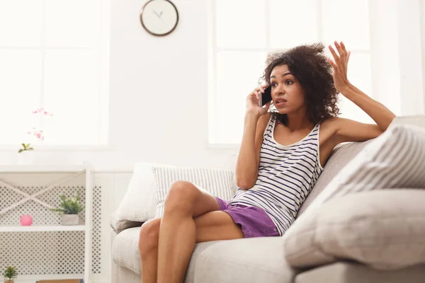 Jovem mulher emocional em casa falando no telefone móvel — Fotografia de Stock