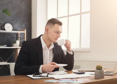 Belgelerle çalışma ve kahve içme genç erkek Yöneticisi