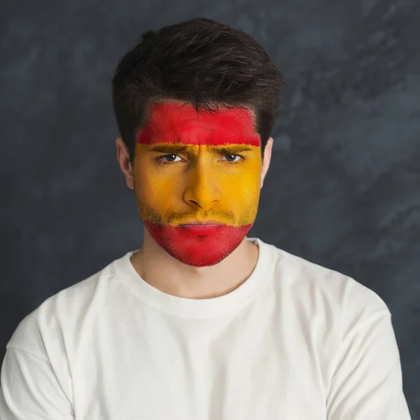 Young man with Spain flag painted on his face