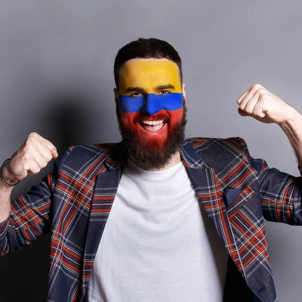 Jovem com bandeira de Columbia pintada em seu rosto — Fotografia de Stock