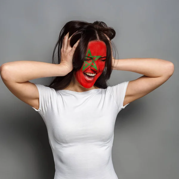 Young woman with Morocco flag painted on her face