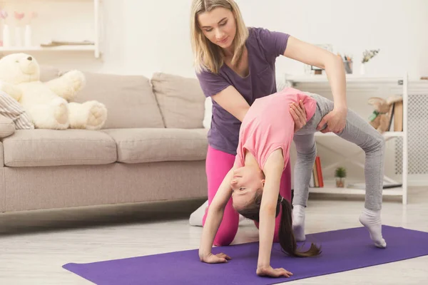 Young woman and child daughter training at home — Stock Photo, Image
