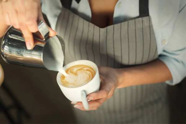 Closeup de barmen derramando leite para copo cappuccino — Fotografia de Stock