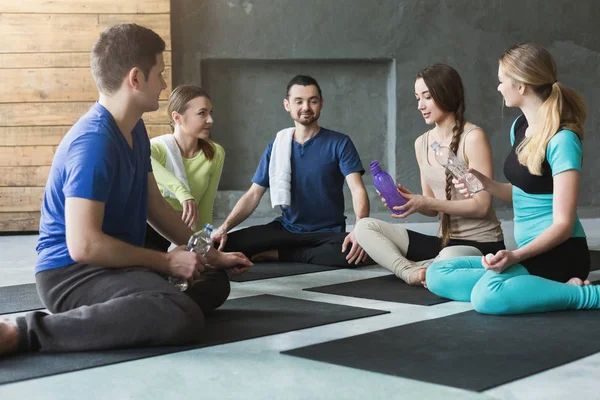 Giovani uomini e donne che si riposano dopo l'allenamento di fitness — Foto Stock