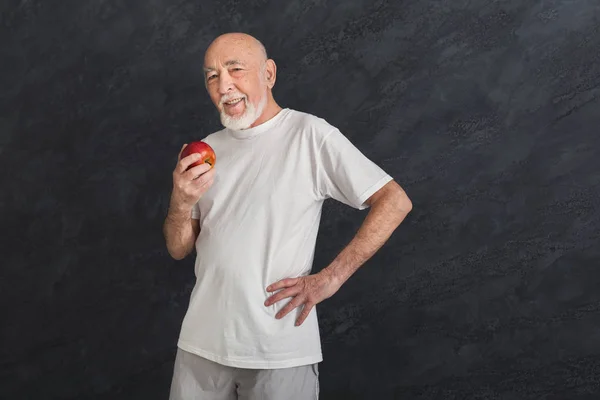 Feliz hombre mayor sosteniendo manzana roja — Foto de Stock
