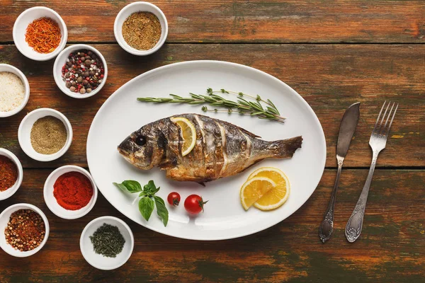 Whole grilled dorado with lemon slices on table — Stock Photo, Image