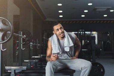 Spor salonunda cep telefonuyla siyah vücut geliştirmeci