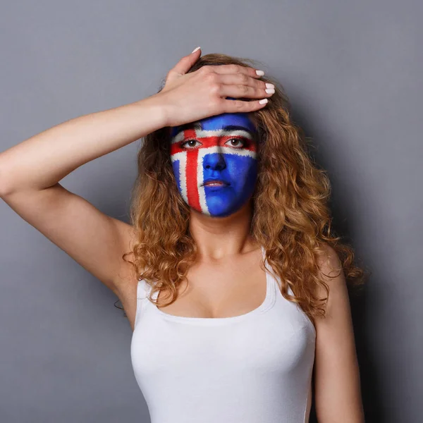 Jovem mulher com bandeira da Islândia pintada em seu rosto — Fotografia de Stock