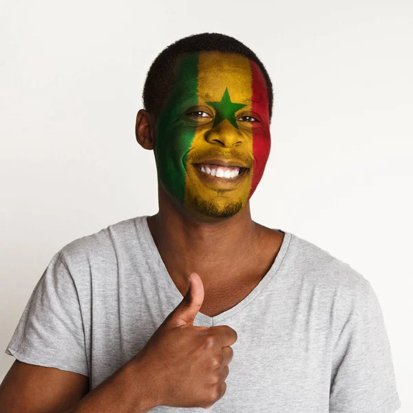 Young man with Senegal flag painted on his face — Stock Photo, Image