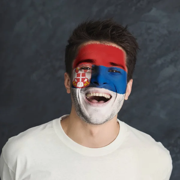 Young man with Serbia flag painted on his face