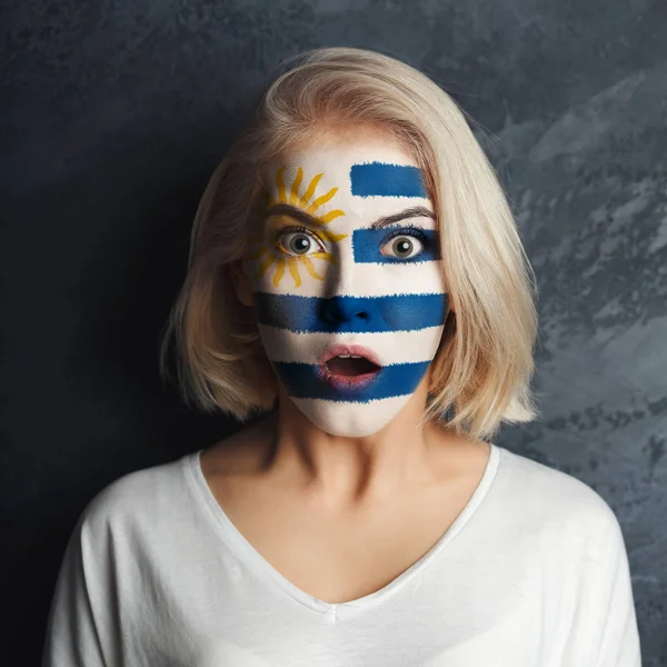 Ung kvinna med Uruguay flagga målad på hennes ansikte — Stockfoto