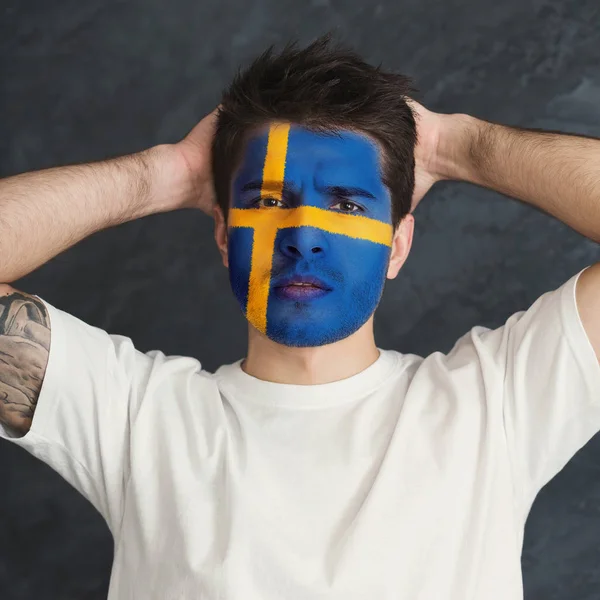 Jovem com bandeira da Suécia pintada em seu rosto — Fotografia de Stock
