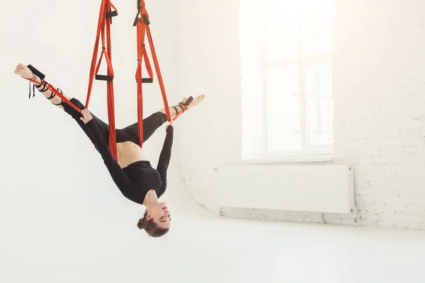 Woman practicing fly yoga over white background