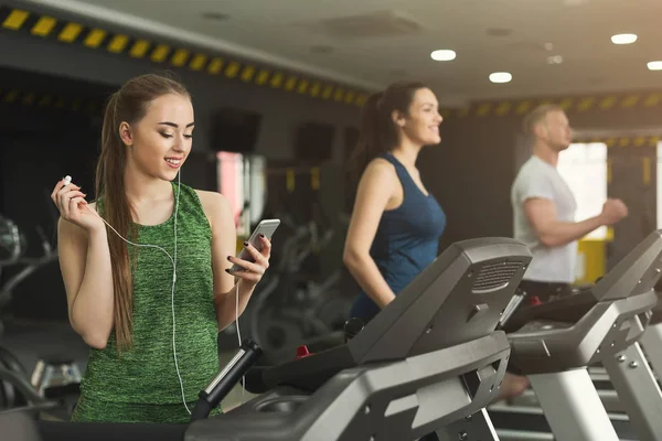 Attraktiv kvinna på löpbandet i gymmet — Stockfoto