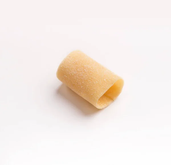 One raw paccheri on white background — Stock Photo, Image