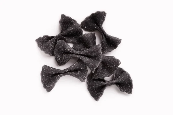 Heap of black farfalle pasta isolated on white — Stock Photo, Image