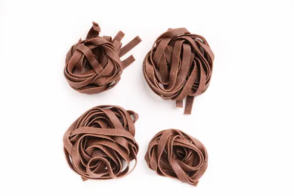 Tagliatelle di pasta al cioccolato crudo impreparato isolato — Foto Stock
