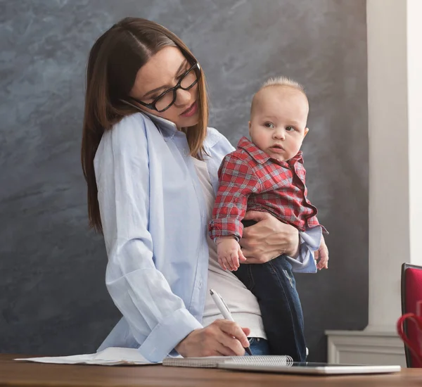 Jeune mère tenant bébé tout en parlant au téléphone — Photo