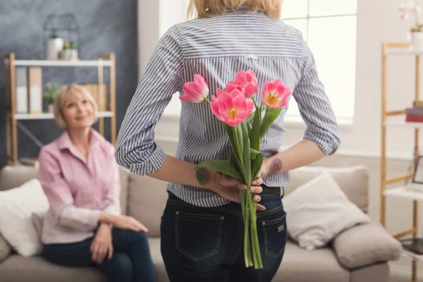Wytatuowany córkę dając kwiaty matki dla dorosłych — Zdjęcie stockowe