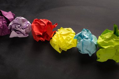 Siyah arka plan üzerinde renkli buruşuk kağıt topları