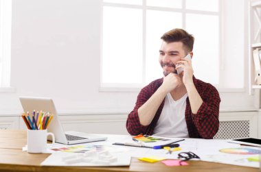 Konsantre genç tasarımcı vardır mobil telefon konuşma