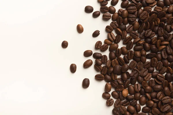 Heap de grãos de café marrom isolado em branco — Fotografia de Stock