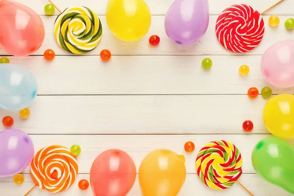 Colorful balloons on white rustic wood, birthday background, top — Stock Photo, Image