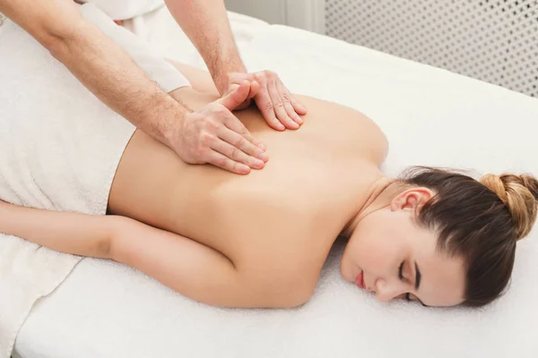 Fechar as mãos massagear as costas femininas — Fotografia de Stock