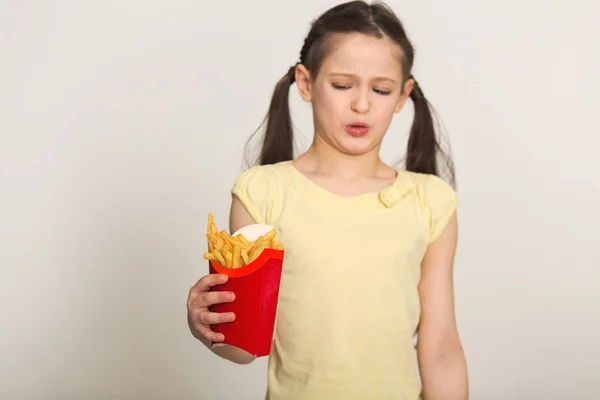 フライド ポテトの袋を保持うんざり少女 — ストック写真