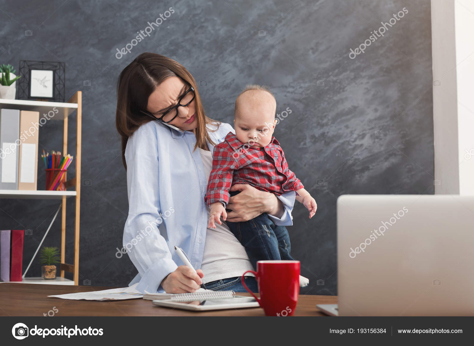 Young mother holding baby while talking on phone — Stock Photo