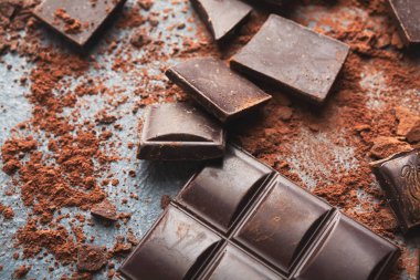 Çikolata parçaları ve gri arka plan üzerine kakao ezilmiş