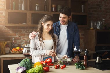 Mutlu çift birlikte yemek pişiriyor.