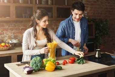 Mutlu çift birlikte yemek pişiriyor.