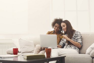 Kredi kartı ve dizüstü bilgisayar ile iki kadın online