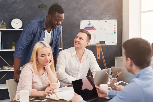 Företagets medarbetare diskuterar idéer i office — Stockfoto