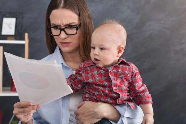 Ung mamma arbetar och umgås med barnet — Stockfoto