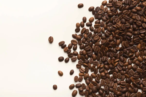 Yığın üzerinde beyaz izole kahverengi kahve çekirdekleri — Stok fotoğraf